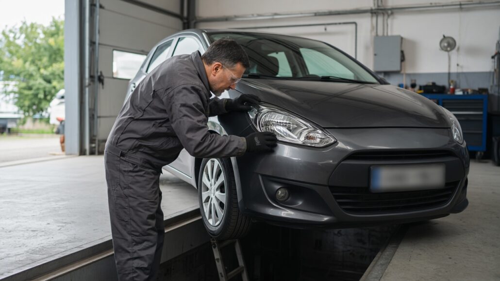 HU und AU: So bereitest du dein Auto auf die Untersuchung vor 2 Kompaktwagen steht in einer offenen Werkstatt über einer Untersuchungsgrube, Tageslicht