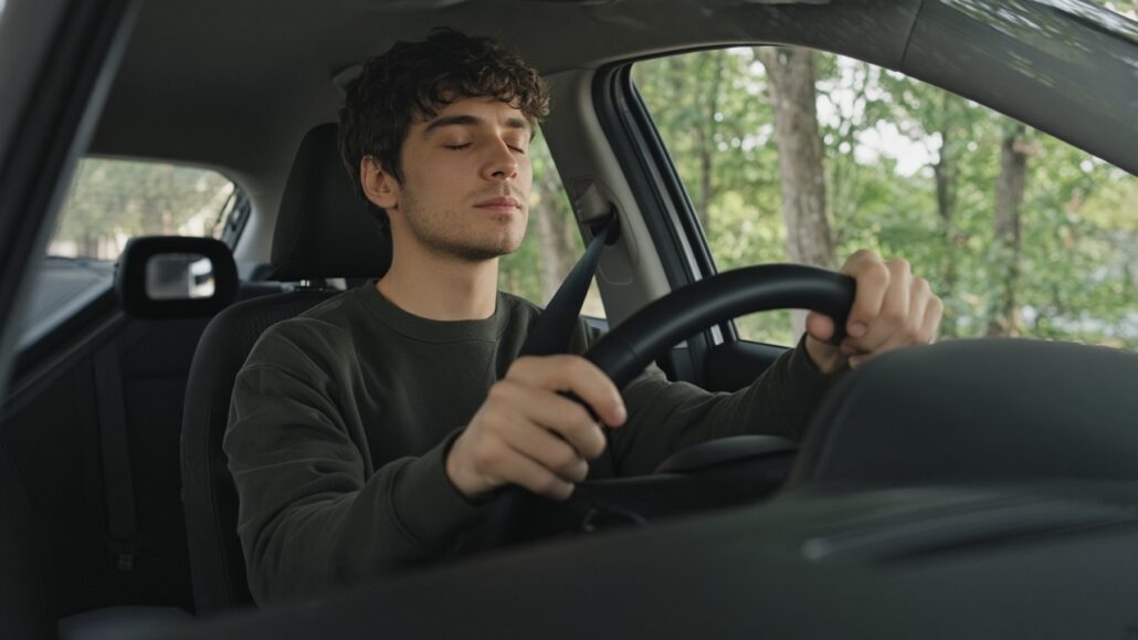 Prüfungsangst beim Führerschein: So bereitest du dich vor 2 Fahrschüler sitzt vor der Prüfung ruhig am Lenkrad und atmet durch
